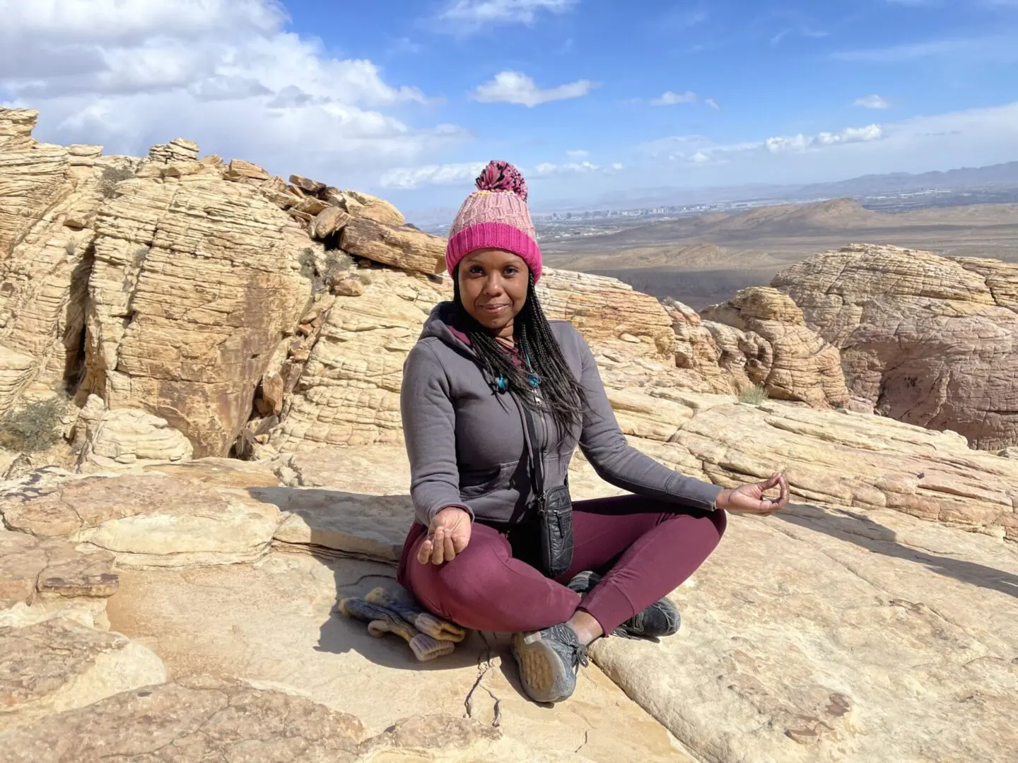 A woman sitting on the ground in front of some rocks