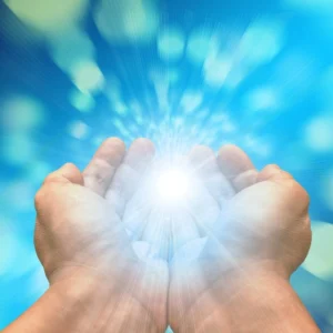 A person is holding their hands out in front of the light.