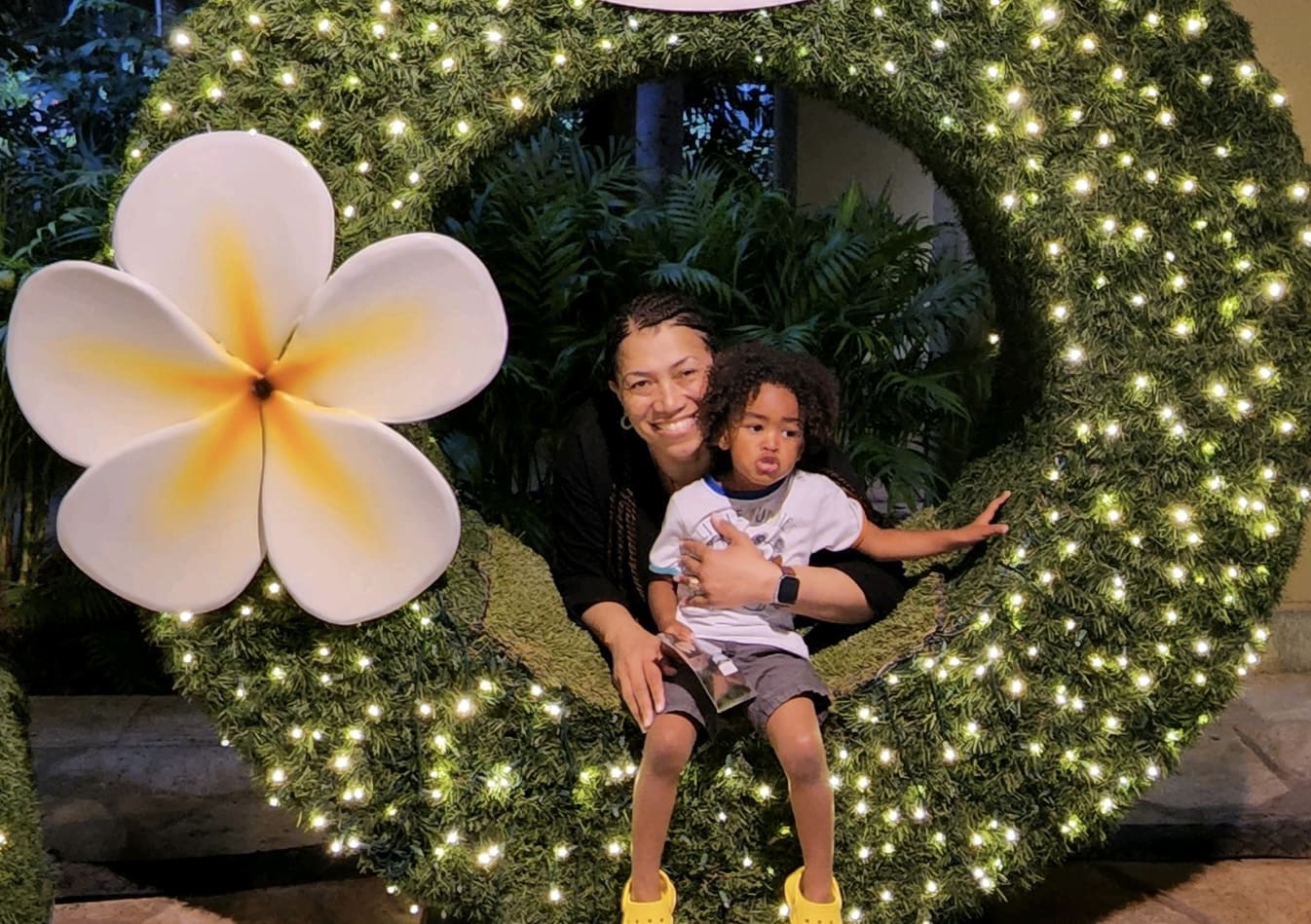 A woman and child sitting in a wreath.