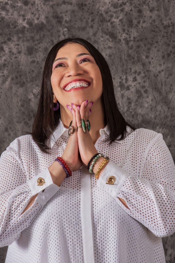 A woman with her hands clasped together.